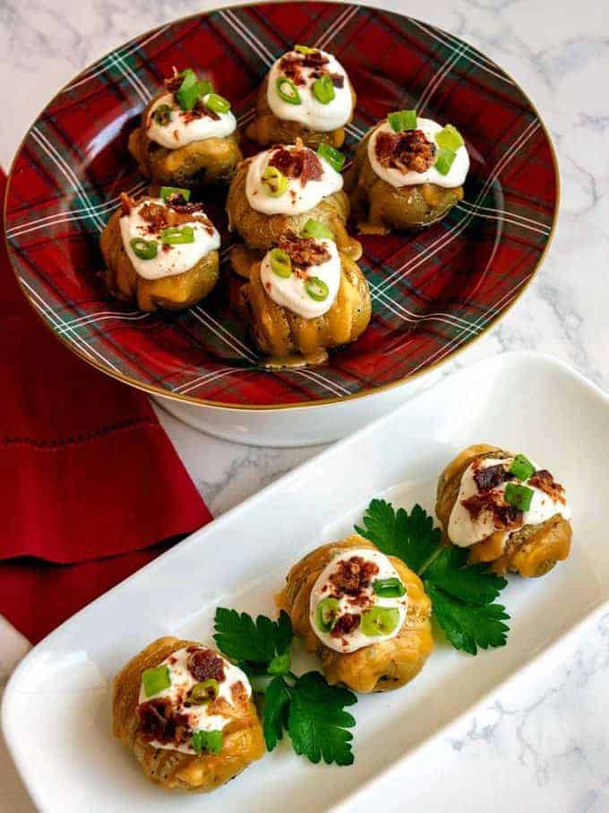 Loaded mini hasselback potato bite appetizers on a serving platter. 