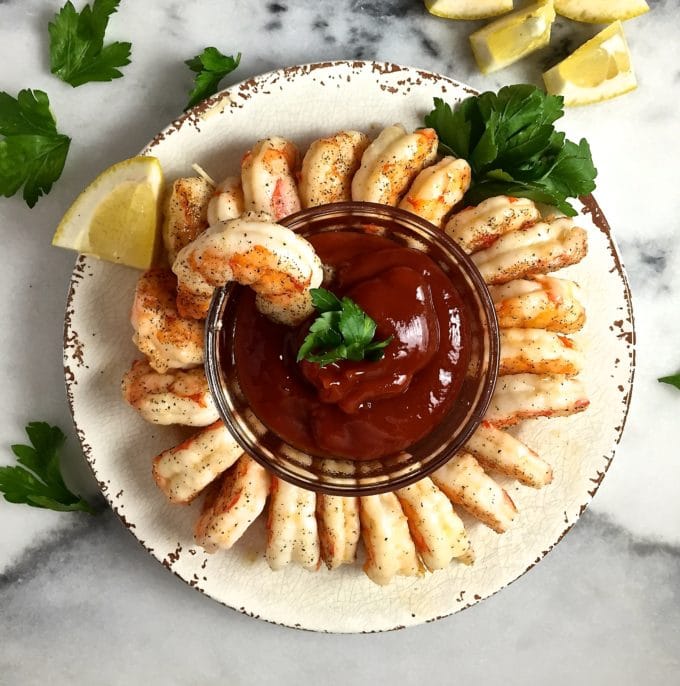 Easy Ten Minute Roasted Shrimp à la Ina Garten served as shrimp cocktail on a plate with cocktail sauce. 