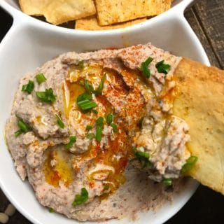 Black-Eyed Pea Hummus and pita chips in white duo bowl.