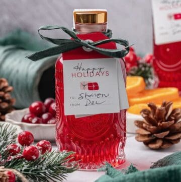 Bottle of cranberry infused vodka tied with ribbon and a gift tag.