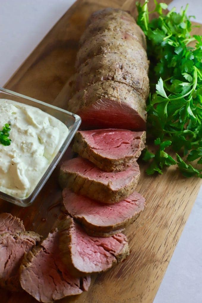 Perfect Beef Tenderloin with Gorgonzola Sauce on a cutting board. Part of a roundup of 23 Easy Dinner Party Recipes. 