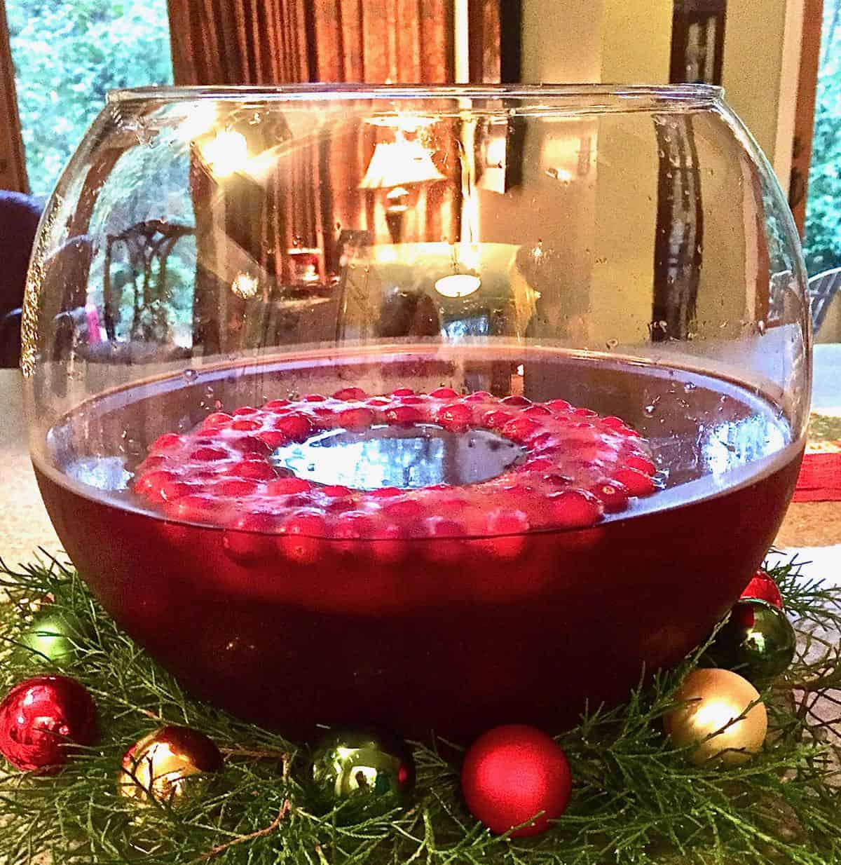 Christmas ornaments surrounding a punch bowl full of punch. 