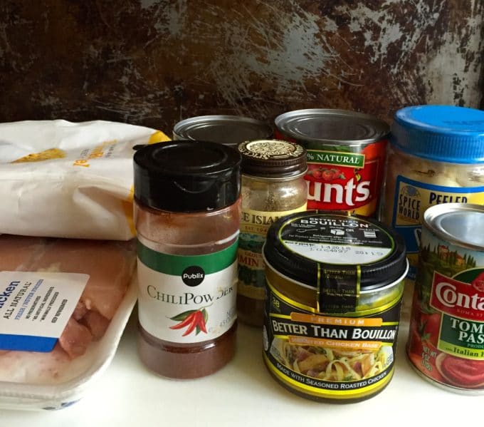 Ingredients for soup including chicken, chili powder, canned tomatoes, garlic and corn.