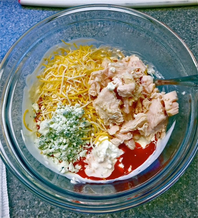 Half the shredded cheese and the rest of the ingredients in a large glass mixing bowl.