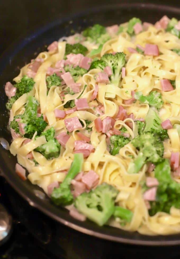 Fettuccine Alfredo with Broccoli and Canadian Bacon in a skillet.