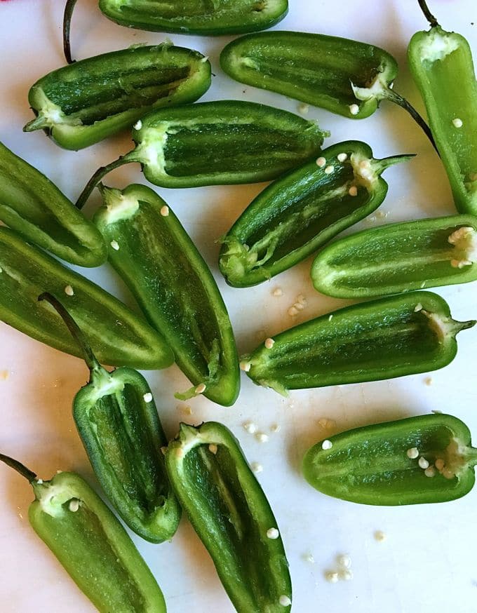 Peppers cut in half with their ribs and seeds removed. 