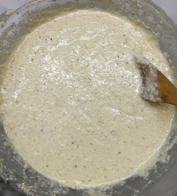 Cornbread batter in a clear class bowl. 