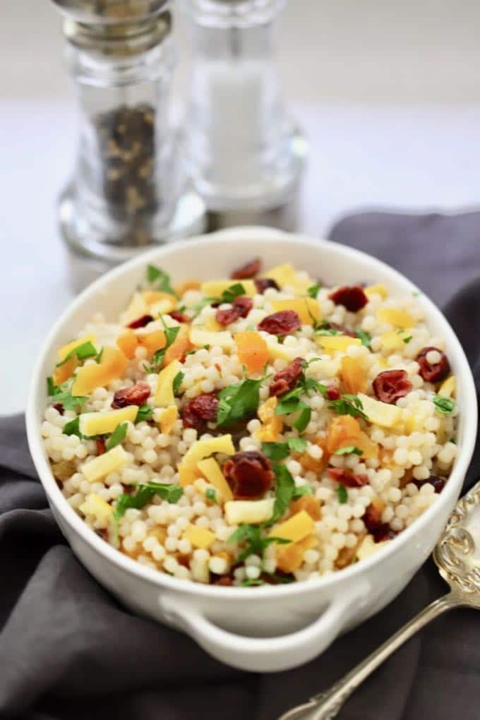 Pearl Couscous with Preserved Lemon in a white serving dish with salt and pepper shakers in the background