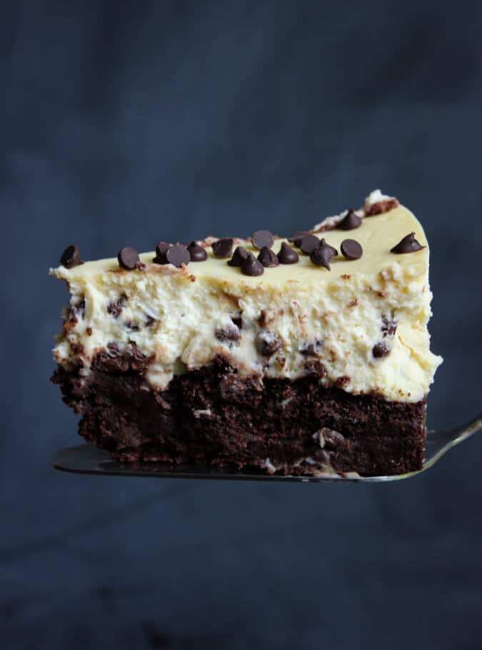 A slice of cheesecake with two layers, one vanilla and the other chocolate. 