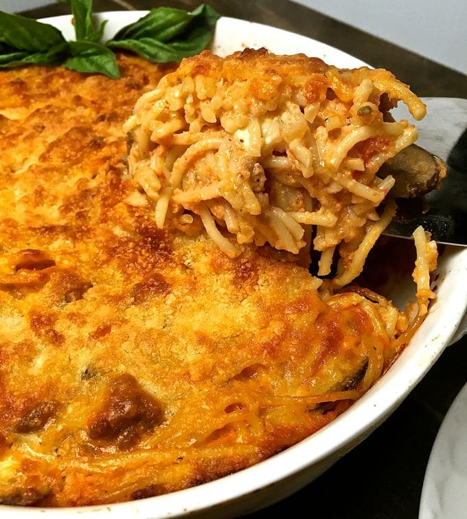 Easy Baked Spaghetti Pie Casserole in a white baking dish with a serving spoon