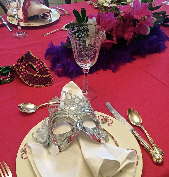 A table set for a mardi gras party for a cookbook club luncheon where Easy Baked Spaghetti Pie Casserole was served