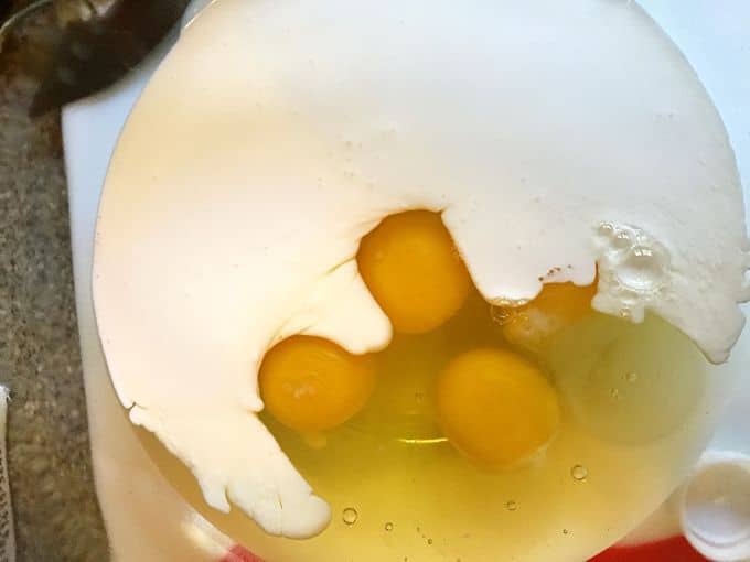 Adding heavy cream and eggs to a clear glass bowl to add to the other Easy Baked Spaghetti Pie Casserole Ingredients