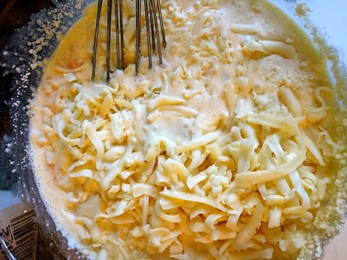 Mixing fontina, Parmesan and feta cheeses together in a bowl for Easy Baked Spaghetti Pie Casserole