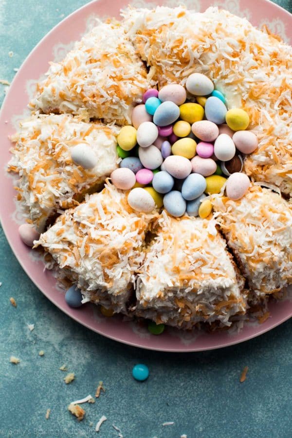 A cake topped with coconut and Easter candy. 