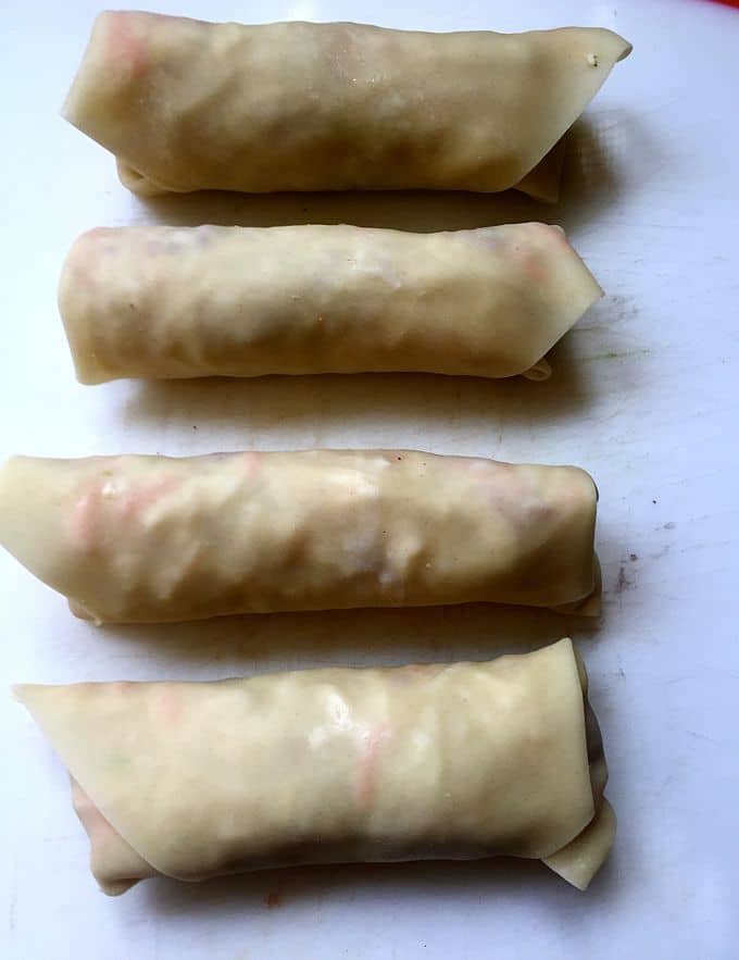 Four Corned-Beef-and-Cabbage-Egg-Rolls ready for the deep fryer.