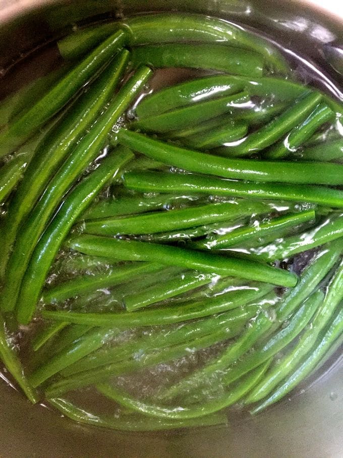 Blanching green beans in large pan of boiling water.