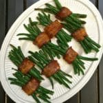 Green Bean Bundles with Bacon on a white serving platter.