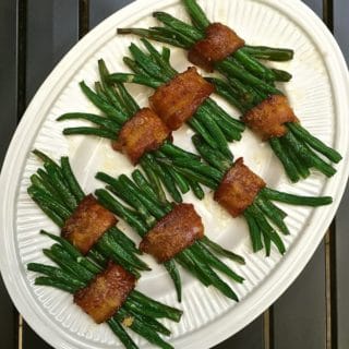 Green Bean Bundles with Bacon on a white serving platter.