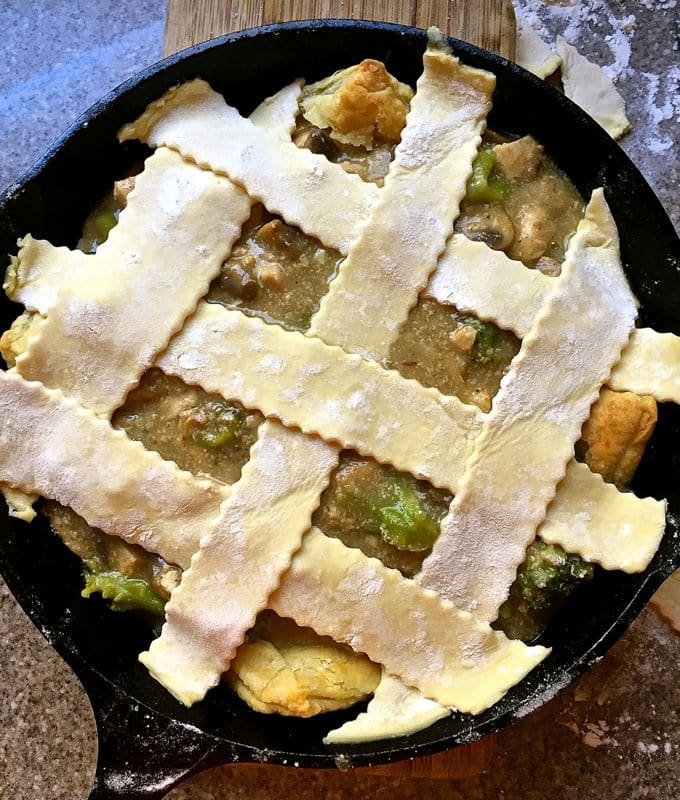 Chicken pot pie with lattice pastry in a cast iron skillet.