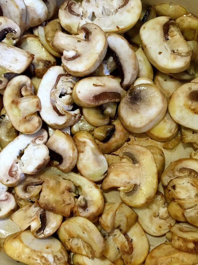 Mushrooms sautéing in a pan.