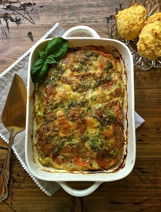 A white casserole dish full of bread pudding on a cutting board. 