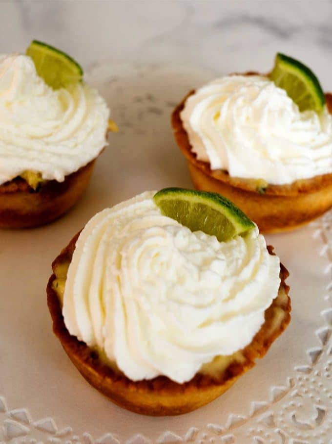 Mexican Lime Key Tartlets topped with whipped cream and garnished with lime slices