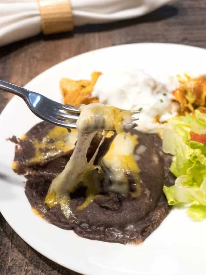 A serving of Instant Pot Smashed Black Beans on a white plate