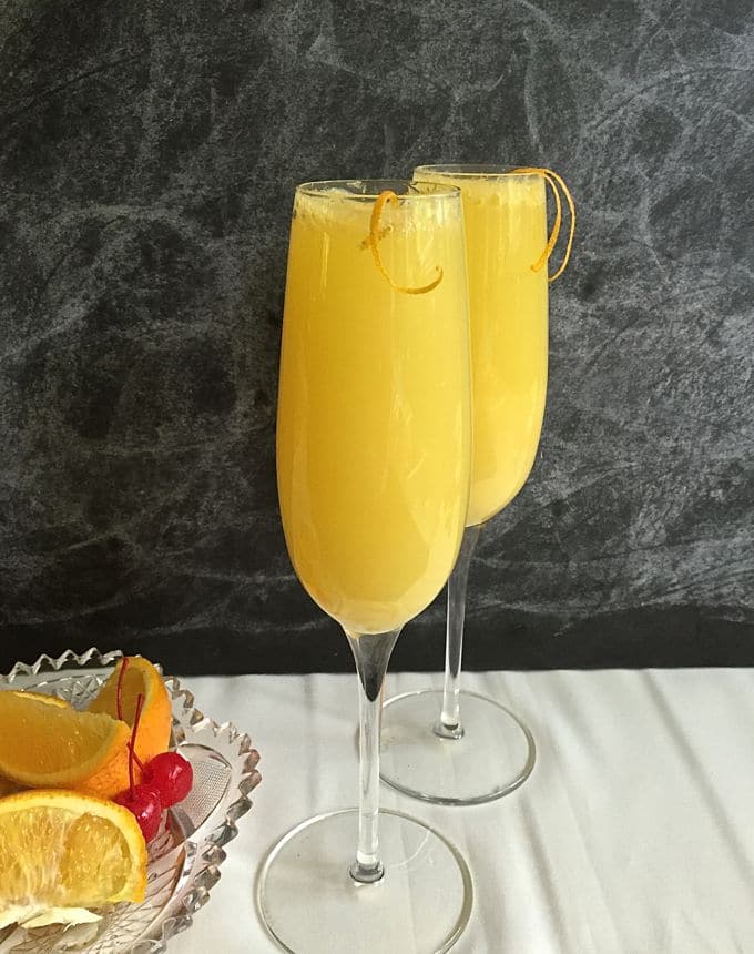 Two champagne glasses full of mimosas. 