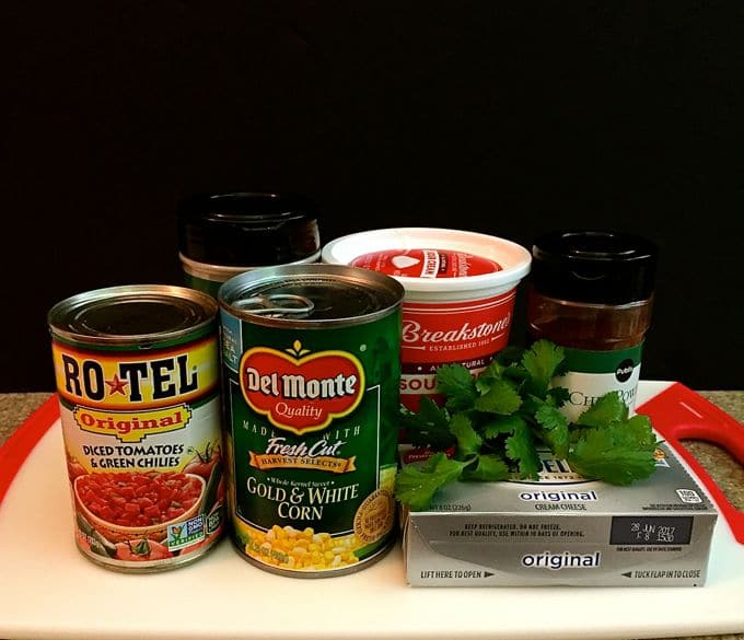 Dip ingredients including corn, a can of Rotel, sour cream and cream cheese.