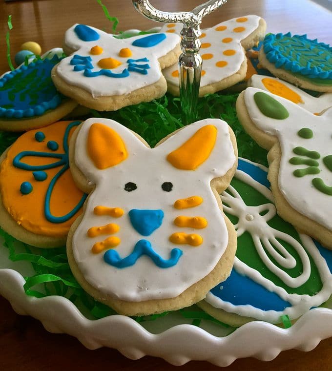 Plate filled with different shaped sugar cookies with icing.