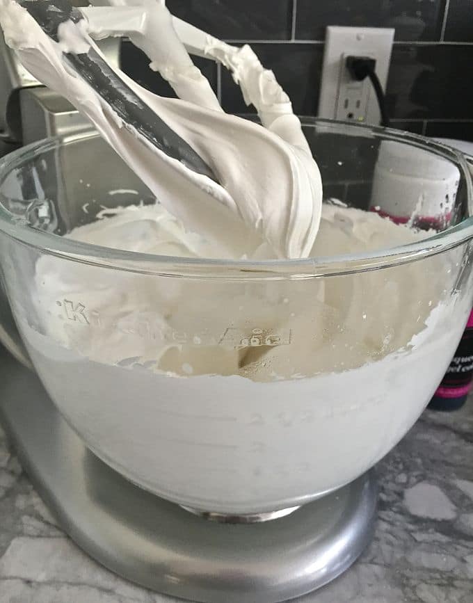 Glass mixing bowl with creamy white icing.
