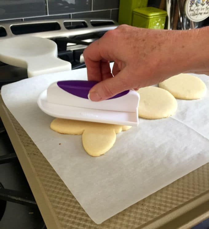 Flattening sugar cookies with a fondant smoother when they come out of the oven.