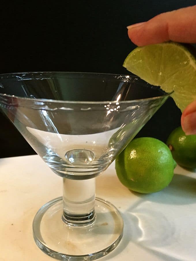 Rubbing a lime on a margarita glass so the salt will stick. 