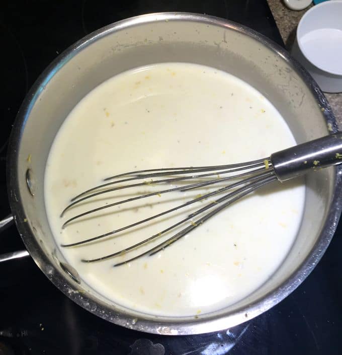 Cooking custard in a saucepan with a metal whisk. 