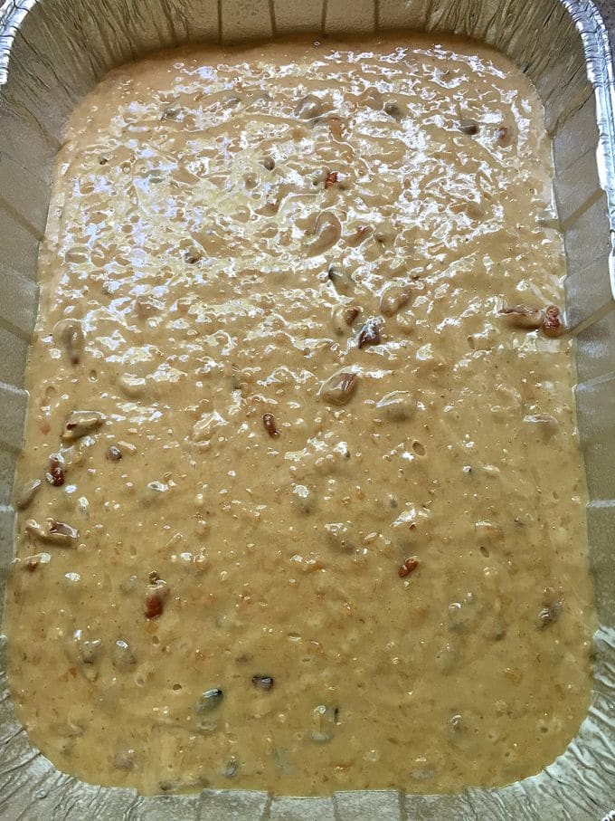 Cake batter poured into an aluminum baking pan.