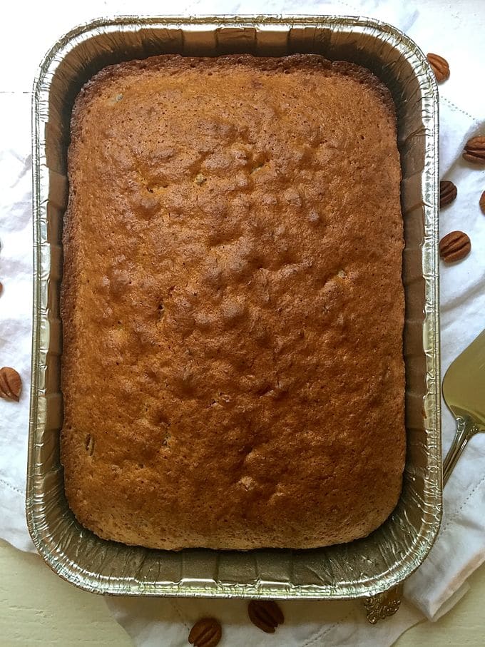 A sheet cake right out of the oven cooling on a white dish towel