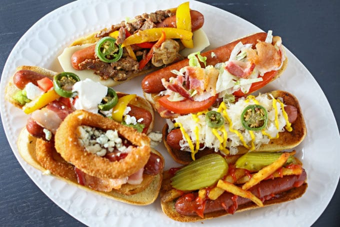 Hot dogs with different toppings on a plate. 