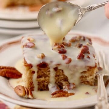 A slice of Southern praline pecan cake on a plate with a sweetened condensed milk topping.