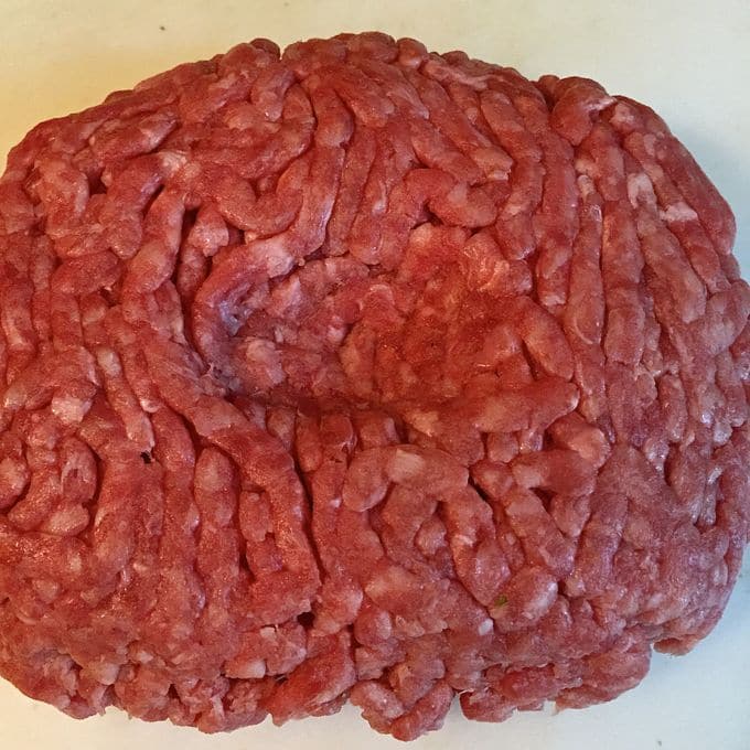 Raw ground beef shaped into a hamburger patty. 