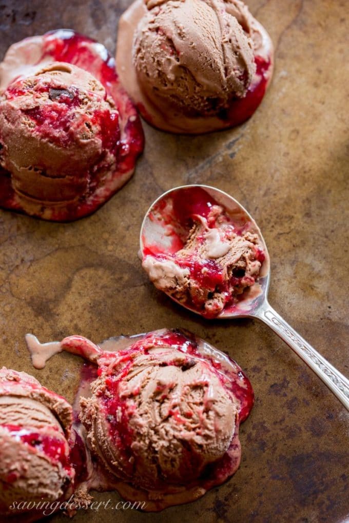 Scoops of Chocolate Chocolate-Chunk Raspberry Ice Cream on a baking sheet. 