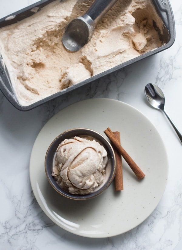 Cinnamon Bun Ice Cream in a metal bowl with two cinnamon sticks. 