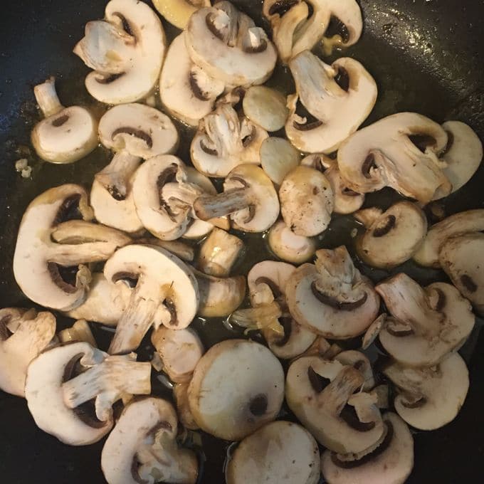 Sautéing mushrooms in a cast iron skillet for Skillet Chicken with Mushroom Sauce 