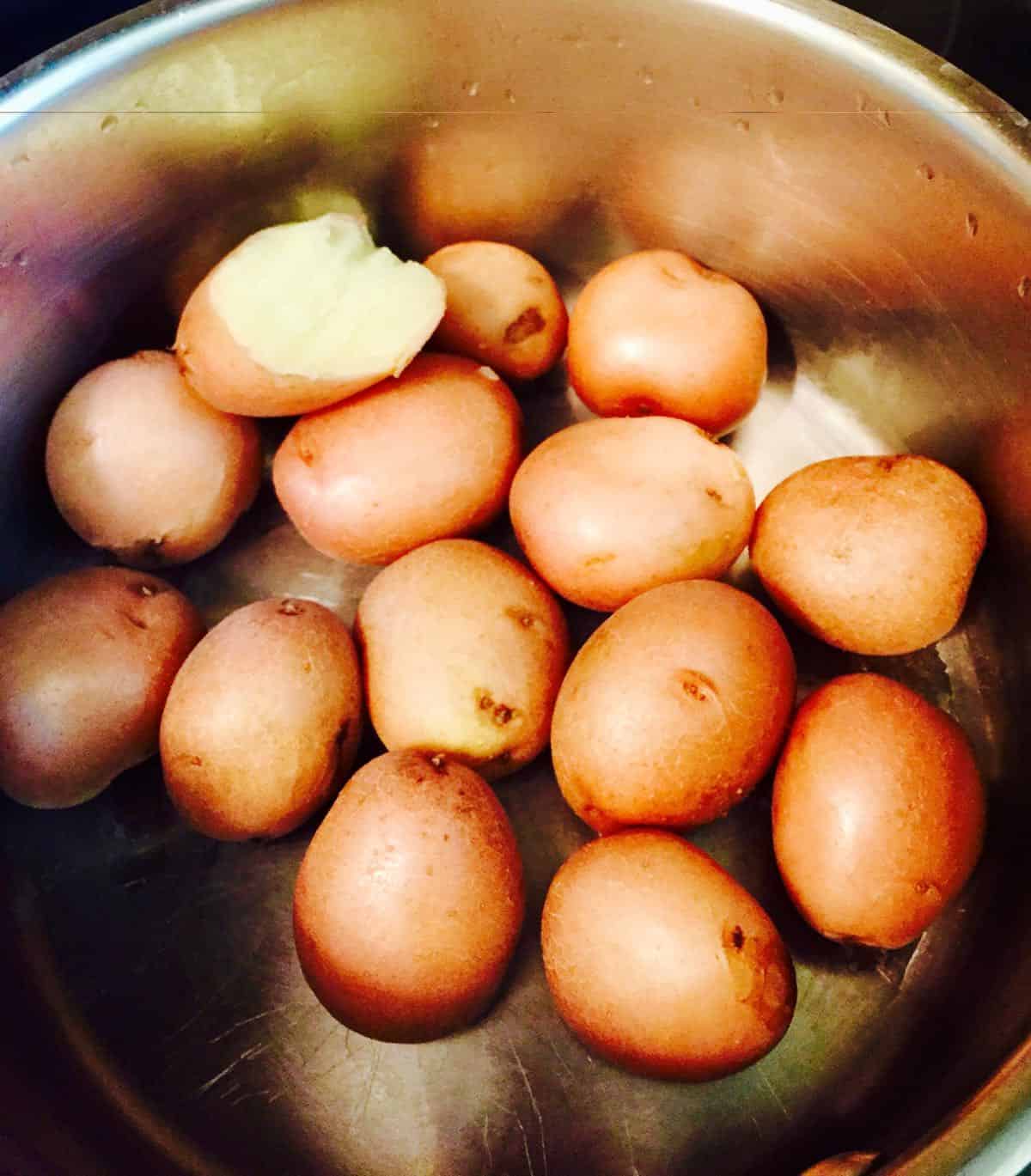 Baby red potatoes in a pan after cooking.