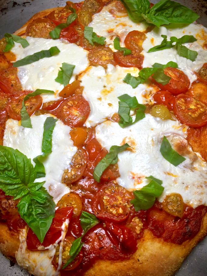 Rustic Roasted Cherry Tomato Pizza hot out of the oven topped with fresh basil. 