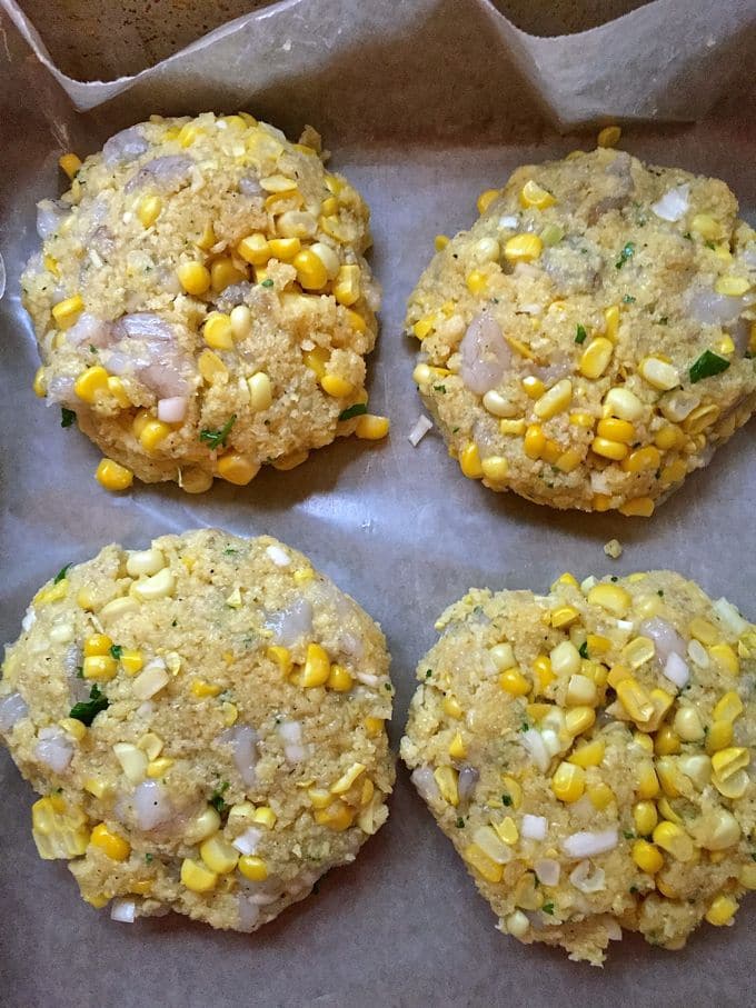 Four shrimp and corn patties ready to cook. 