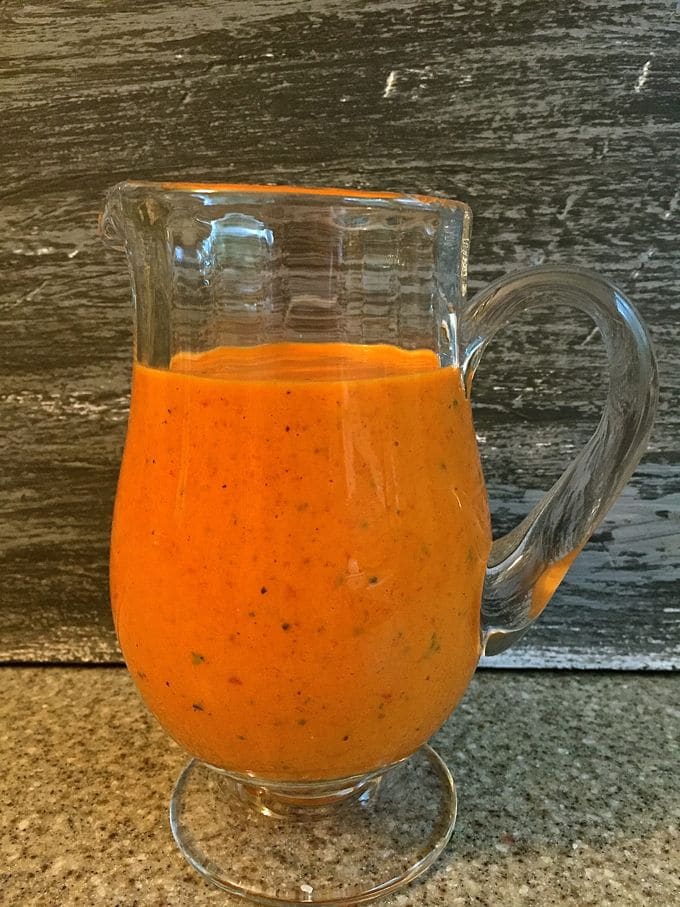 Roasted Red Pepper Sauce in a clear glass pitcher. 