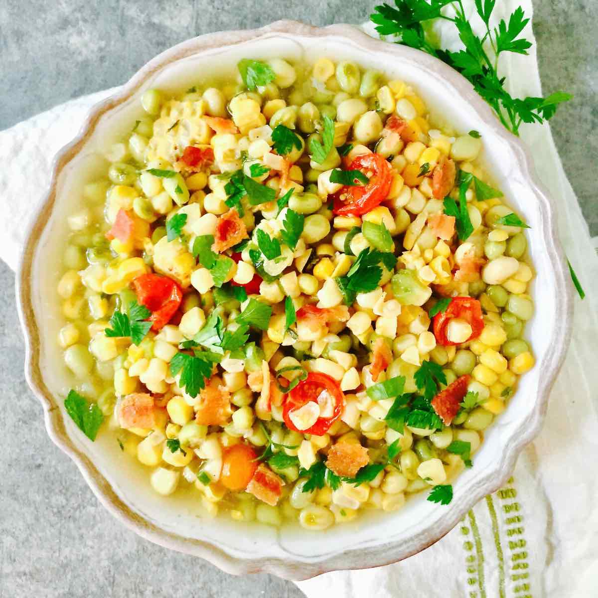 A large bowl of succotash with corn and white acre peas. 