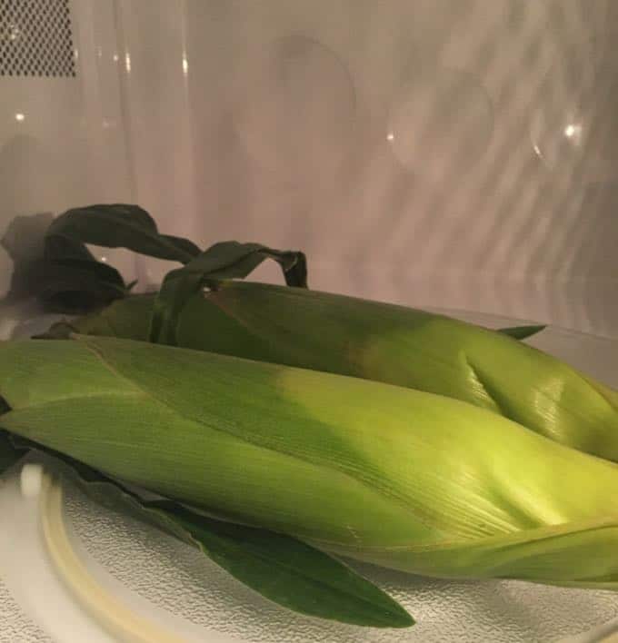 Cooking two ears of corn in the microwave. 