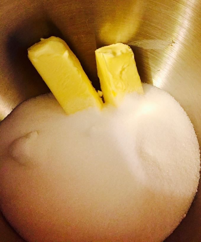 Butter and sugar in a metal mixing bowl ready to be combined together. 