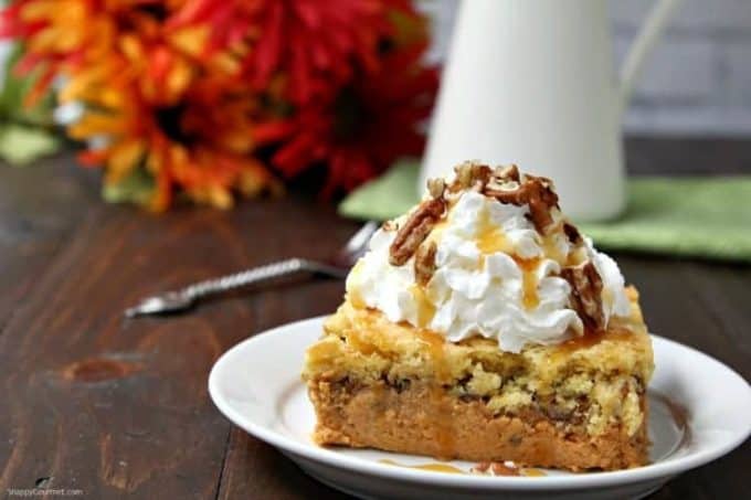 Pumpkin Dump Cake on a white plate topped with whipped cream.